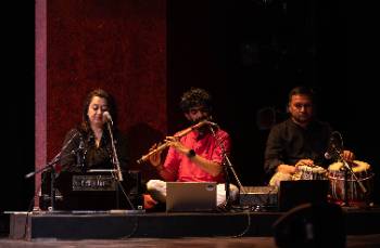 A photo depicting a performance of "Kingdom of Cards," depicting the three musicians who performed live vocals and music for the production.
