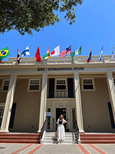 Carlotta Zorzi, dressed in white, standing on the steps of I-House