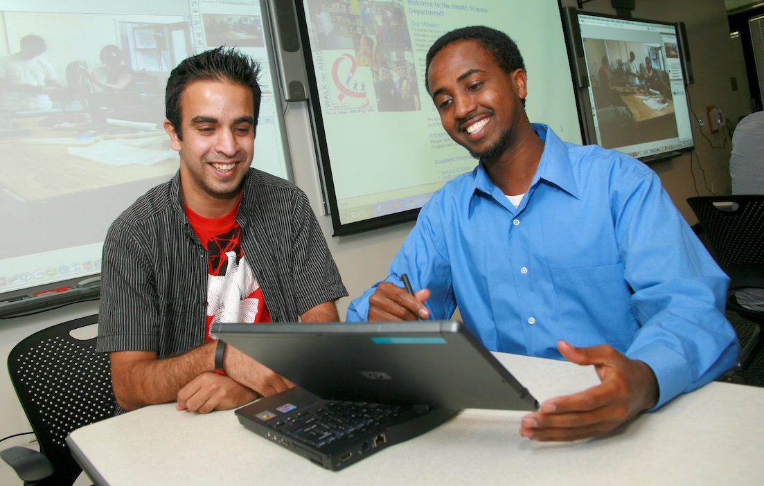 Two people collaborating over a laptop