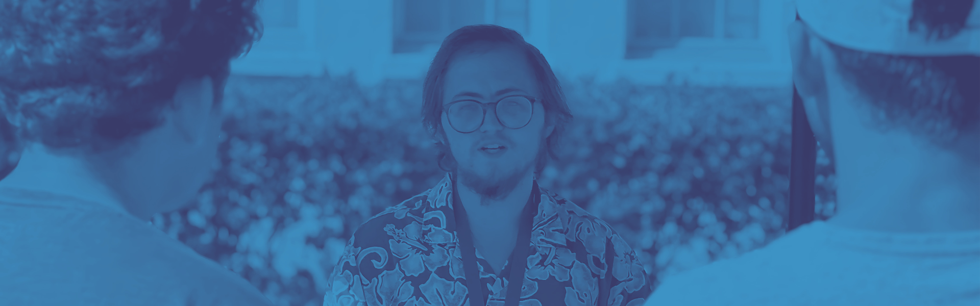 Tutor wearing lanyard talking to students outside